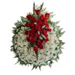 Corona de flores imperial con moño central de 25 rosas rojas y base de maules blancos de 70 cm.